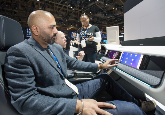 올해 초 미국 라스베이거스에서 열린 세계 최대 전자 전시회 CES 2019 행사장에서 관람객이 삼성전자의 차량용 인포테인먼트 시스템 '디지털 콕핏 2019'를 시연하고 있다. <삼성전자 제공>